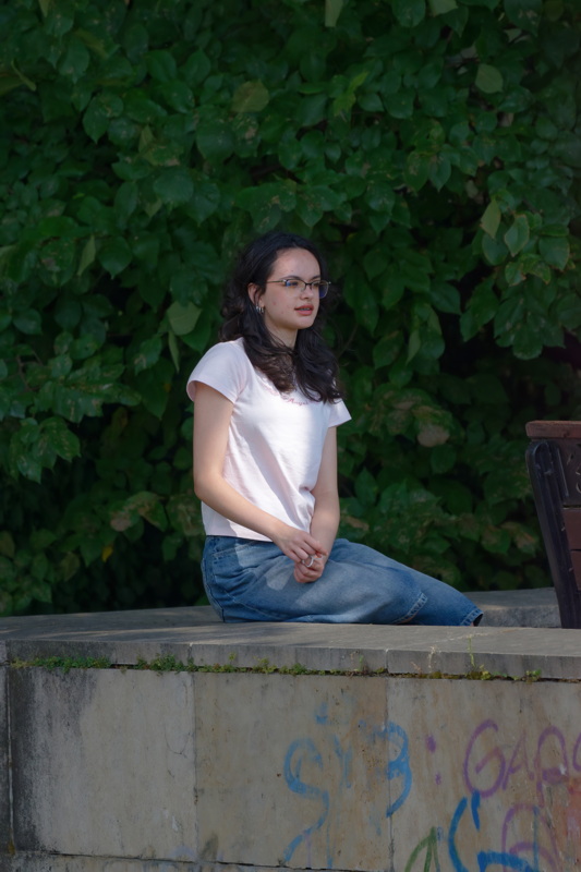 Girl on a concrete fence in park